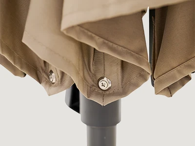 Detailansicht eines beigen, gefalteten Schirmbezugs mit verschraubten Strebenenden am unteren Rand.