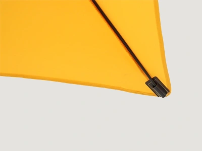 Detailaufnahme einer Schirmdachspitze mit schwarzer Strebe unter gelbem Schirmdach.