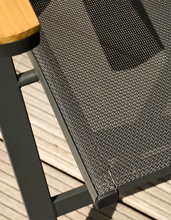 Detailaufnahme einer schwarzen Outdoor Stuhlfläche aus feinmaschigem Textilgewebe mit Holzarmlehne.