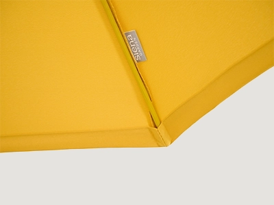 Detail der gelben Schirmkante mit sichtbarem Markenetikett.