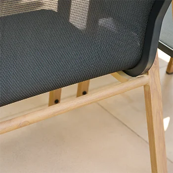 Detailaufnahme der Gartensessel-Sitzfläche aus dunkelgrauem Textilgewebe mit Holzgestell auf einer hellen Terrassenplatte.