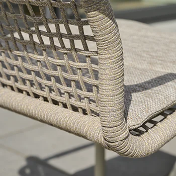 Nahaufnahme der Rückenlehne eines Outdoor Stuhls mit geflochtenem Seilgewebe und gepolstertem Sitzkissen in neutralen Beige  und Grautönen.