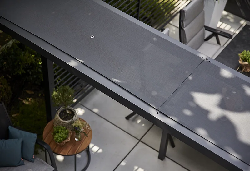 Detailaufnahme einer grauen Pergola Dacherweiterung aus Textilgewebe in anthrazit, von oben fotografiert.