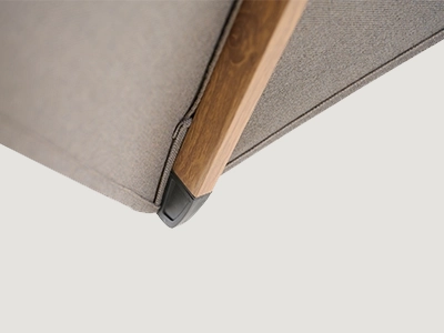 Nahaufnahme einer Schirmstrebe in Holzoptik mit dunkler Endkappe an beigefarbener Bespannung.