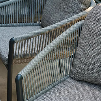 Nahaufnahme zweier Gartenstühle mit seitlicher Bespannung aus straff gespanntem Rope Geflecht und grauen, strukturierten Sitz  und Rückenpolstern