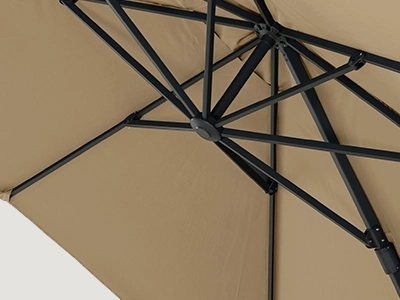Blick unter das beigefarbene Schirmdach auf das schwarze Streben System eines Ampelschirms.